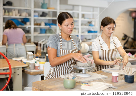Woman teacher and student sculpt ceramic products Woman teacher and student sculpt ceramic products 119538945