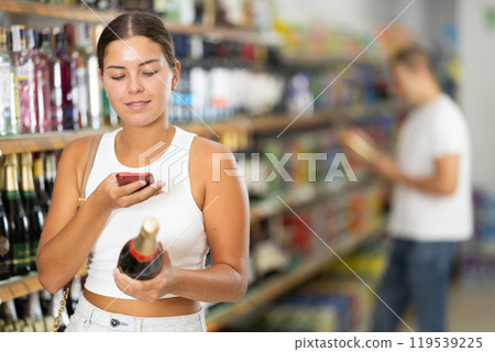 Young woman scanning qr code for champagne 119539225