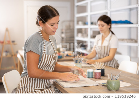 Woman teacher and student sculpt ceramic products Woman teacher and student sculpt ceramic products 119539246