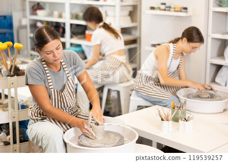 Woman teacher and students make products on potter's wheel 119539257