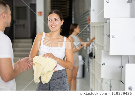 Young woman and man exchanged couple of phrases in locker room after changing clothes 119539426