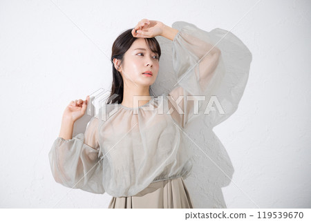 A young woman with a lustrous and clear skin, with an ennui expression that represents the image of sunlight, beauty and beauty. 119539670