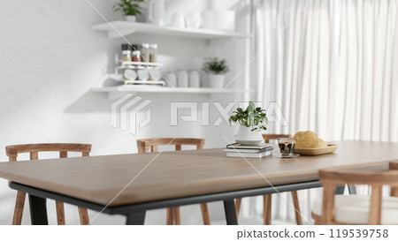 A close-up of a wooden dining table with home decor in a minimalist white dining room. A close-up of a wooden dining table with home decor in a minimalist white dining room. 119539758