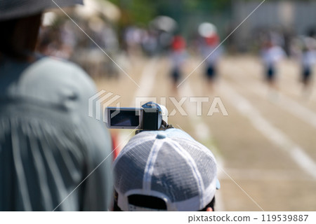 Parents taking video of the sports day on a video camera 119539887