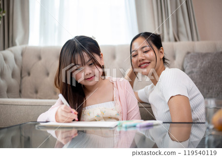 A caring and kind Asian mom is teaching her daughter to draw, enjoying quality family time together. A caring and kind Asian mom is teaching her daughter to draw, enjoying quality family time together. 119540119
