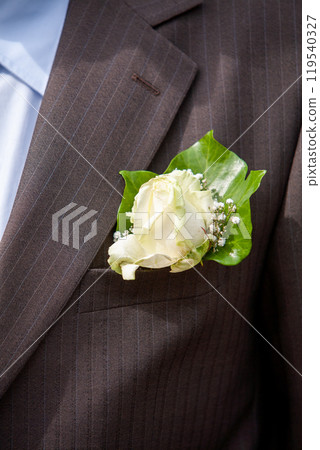An Elegant Boutonniere featuring a White Rose complemented by Green Foliage for style 119540327