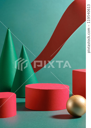 Next to empty red circular and rectangular forms, for product displays stand two green cone-shaped objects; a gold sphere and a crimson ribbon flow nearby. Simple Christmas advertisement image. 119540613