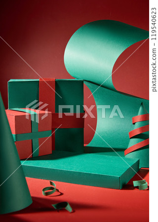 A simple Christmas space is created with a green platform as a showcase for products; red and green present boxes, Noel decorations, and paper rolls are suspended behind the platform. A simple Christmas space is created with a green platform as a showcase for products; red and green present boxes, Noel decorations, and paper rolls are suspended behind the platform. 119540623