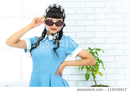 A woman in Showa retro fashion wearing sunglasses A woman in Showa retro fashion wearing sunglasses 119540917