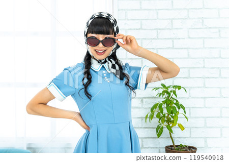 A woman in Showa retro fashion wearing sunglasses A woman in Showa retro fashion wearing sunglasses 119540918