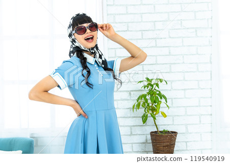 A woman in Showa retro fashion wearing sunglasses A woman in Showa retro fashion wearing sunglasses 119540919