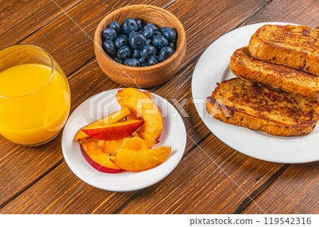 French toast on a plate with blueberries, orange juice, nectarine for breakfast French toast on a plate with blueberries, orange juice, nectarine for breakfast 119542316