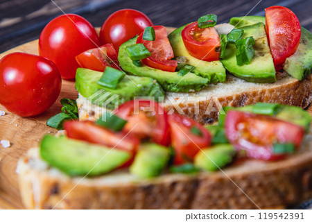 Avocado toast topped with tomato and green onion on a slice of carrot bread Avocado toast topped with tomato and green onion on a slice of carrot bread 119542391