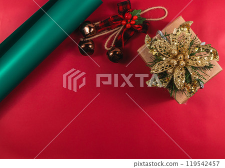 Christmas composition with a gift box and decorations with bells and a bow Christmas composition with a gift box and decorations with bells and a bow 119542457