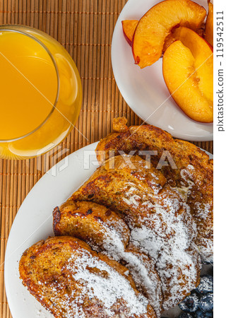 French toast on a plate with blueberries, orange juice, nectarine for breakfast French toast on a plate with blueberries, orange juice, nectarine for breakfast 119542511