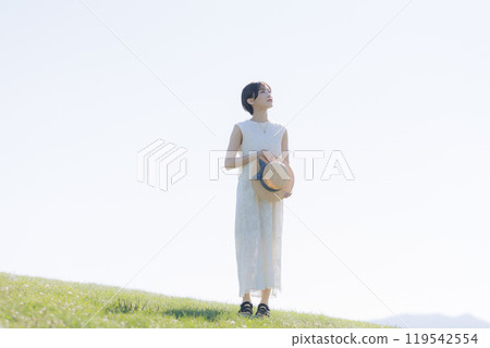 Young woman standing on a hill Young woman standing on a hill 119542554