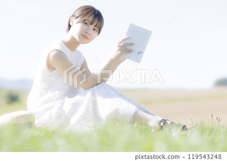 草地上讀書的年輕女子 119543248
