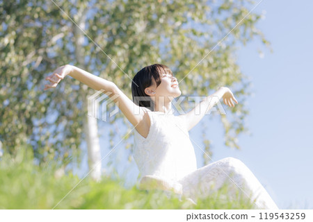 草地上讀書的年輕女子 119543259