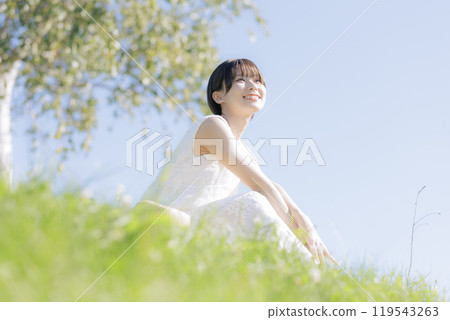 Young woman reading a book in the grass 119543263