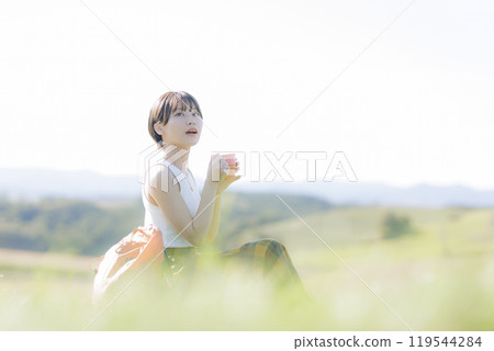 Young woman sitting and relaxing on the grass 119544284