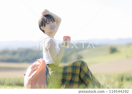 Young woman sitting and relaxing on the grass 119544292