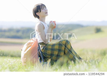 Young woman sitting and relaxing on the grass 119544294