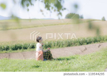 Young woman sitting and relaxing on the grass Young woman sitting and relaxing on the grass 119544295