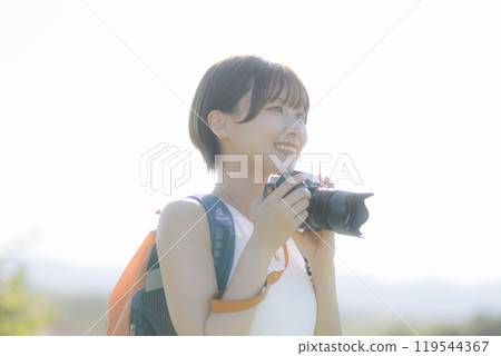 Young woman holding a camera in the grass Young woman holding a camera in the grass 119544367