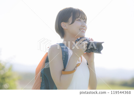 Young woman holding a camera in the grass Young woman holding a camera in the grass 119544368