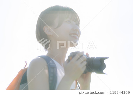 Young woman holding a camera in the grass Young woman holding a camera in the grass 119544369