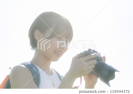 草地上拿著相機的年輕女子 119544372