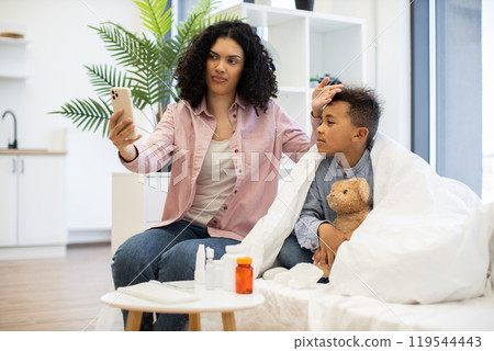 Mother and child video call doctor for remote healthcare assistance Mother and child video call doctor for remote healthcare assistance 119544443