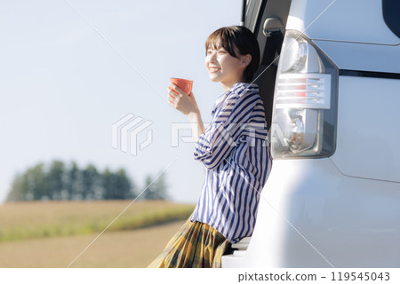 Young woman relaxing sitting in a trunk Young woman relaxing sitting in a trunk 119545043