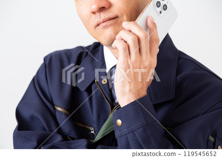 A middle-aged male businessman in work clothes worried while talking on his smartphone 119545652