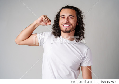 Happy man celebrating success with raised fists in a studio against a plain background Happy man celebrating success with raised fists in a studio against a plain background 119545708