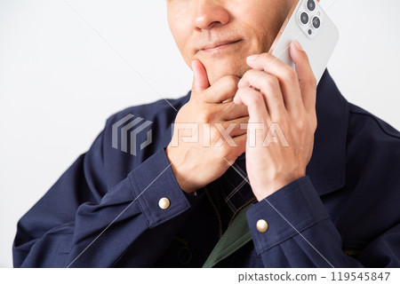 A middle-aged male businessman in work clothes worried while talking on his smartphone A middle-aged male businessman in work clothes worried while talking on his smartphone 119545847