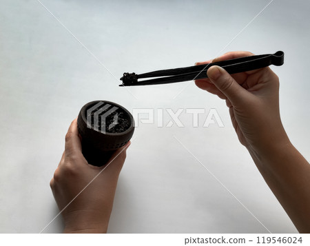 Hands preparing hookah bowl with charcoal on white background 119546024