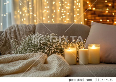 Cozy living room setting with candles and flowers illuminated by warm fairy lights in the evening 119546030