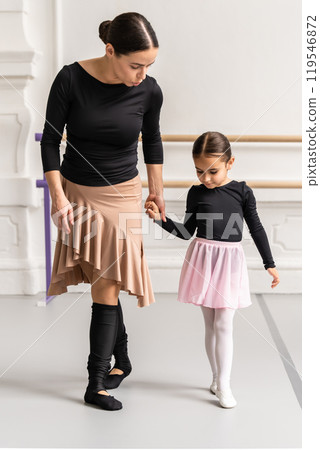 Winsome woman and little girl practicing ballet together in hall learning dancing 119546872