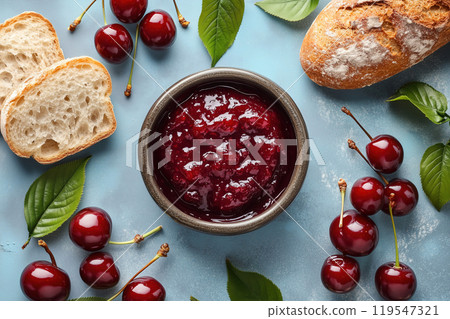 Delicious cherry jam served with fresh bread and ripe cherries on a blue background for a tempting 119547321