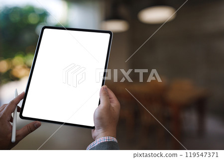 A businessman holds a mockup. iPad digital tablet with blank screen Mockup replaces your design mockup in the office. A businessman holds a mockup. iPad digital tablet with blank screen Mockup replaces your design mockup in the office. 119547371