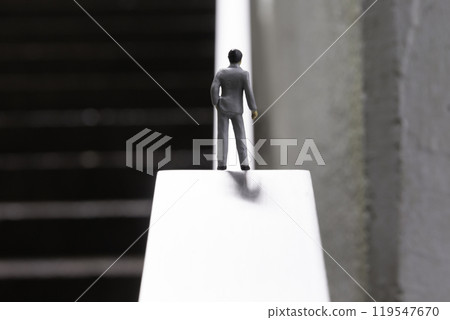 A male doll in a business suit standing in front of an uphill slope Image of life and career 119547670