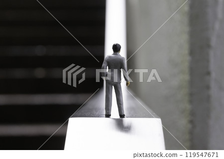 A male doll in a business suit standing in front of an uphill slope Image of life and career A male doll in a business suit standing in front of an uphill slope Image of life and career 119547671