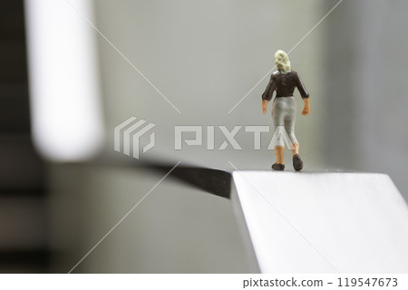 A female doll in a business suit standing in front of an uphill slope Image of life and career A female doll in a business suit standing in front of an uphill slope Image of life and career 119547673