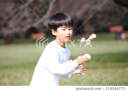 A boy practicing Kendama A boy practicing Kendama 119548771