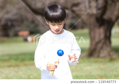 A boy practicing Kendama 119548773