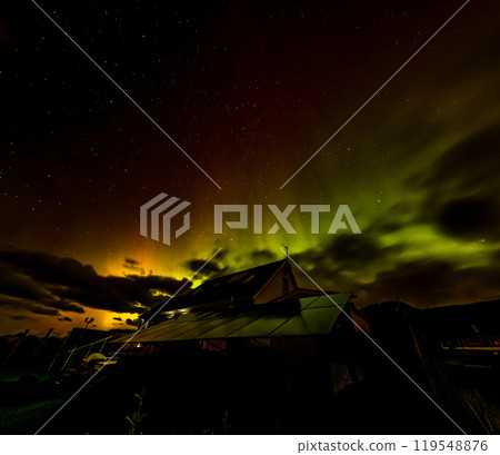 The Aurora Borealis, the northern lights, showing up above bungalow in County Donegal, Ireland 119548876