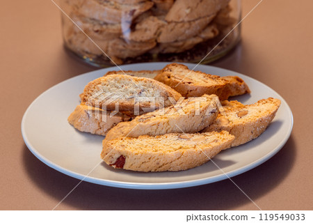 Almond cantucci cookies are arranged on a plate revealing their crisp texture and nutty flavor 119549033