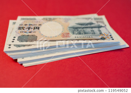 Macro shot of yen bills on vibrant red backdrop Macro shot of yen bills on vibrant red backdrop 119549052