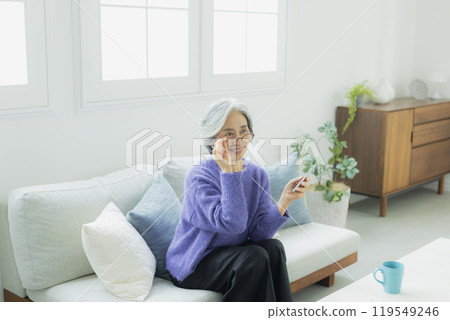 一位身穿針織品的高級女性在客廳放鬆 119549246